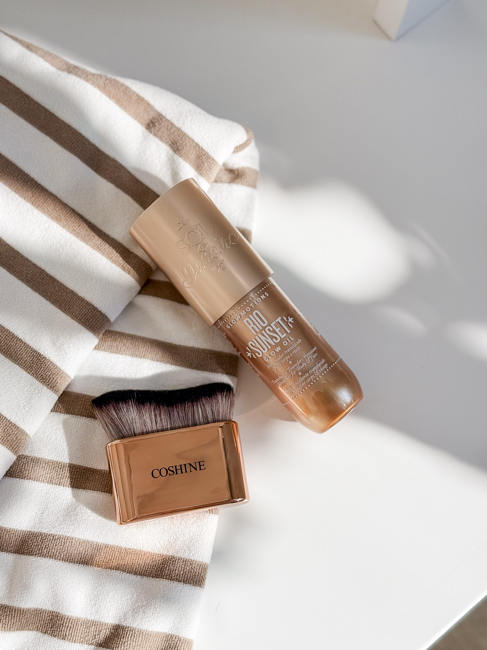 jordyn's summer favorites | image of striped towel, glow oil for the body, and a blend brush