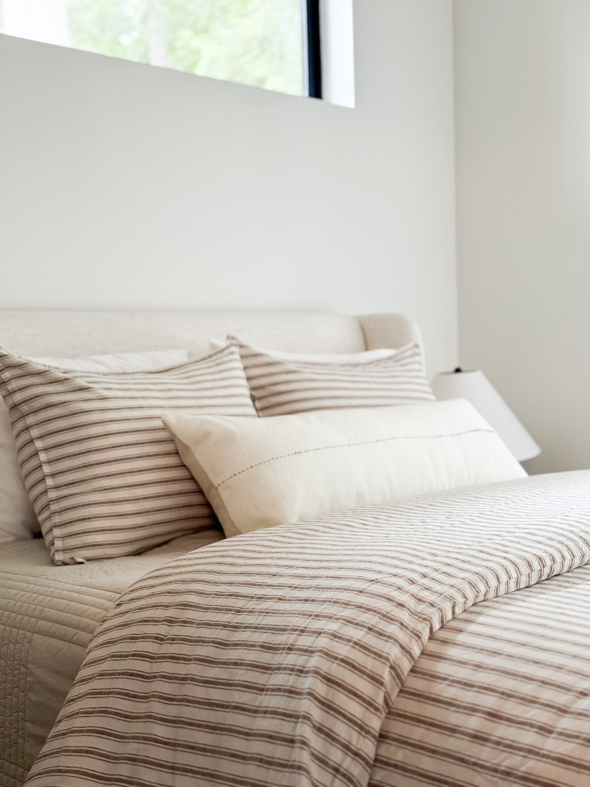 cabin decor essentials | a photo featuring a bedroom with striped linens