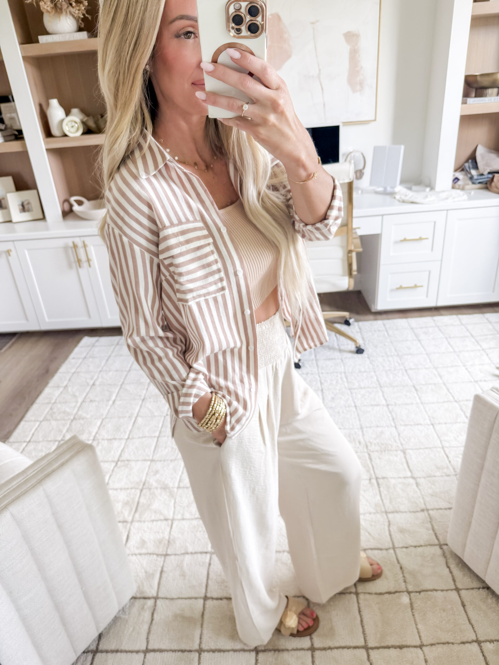 jordyn's summer favorites | image of a woman wearing a striped button down shirt, tank top, high waisted wide leg pants, and gold bracelets