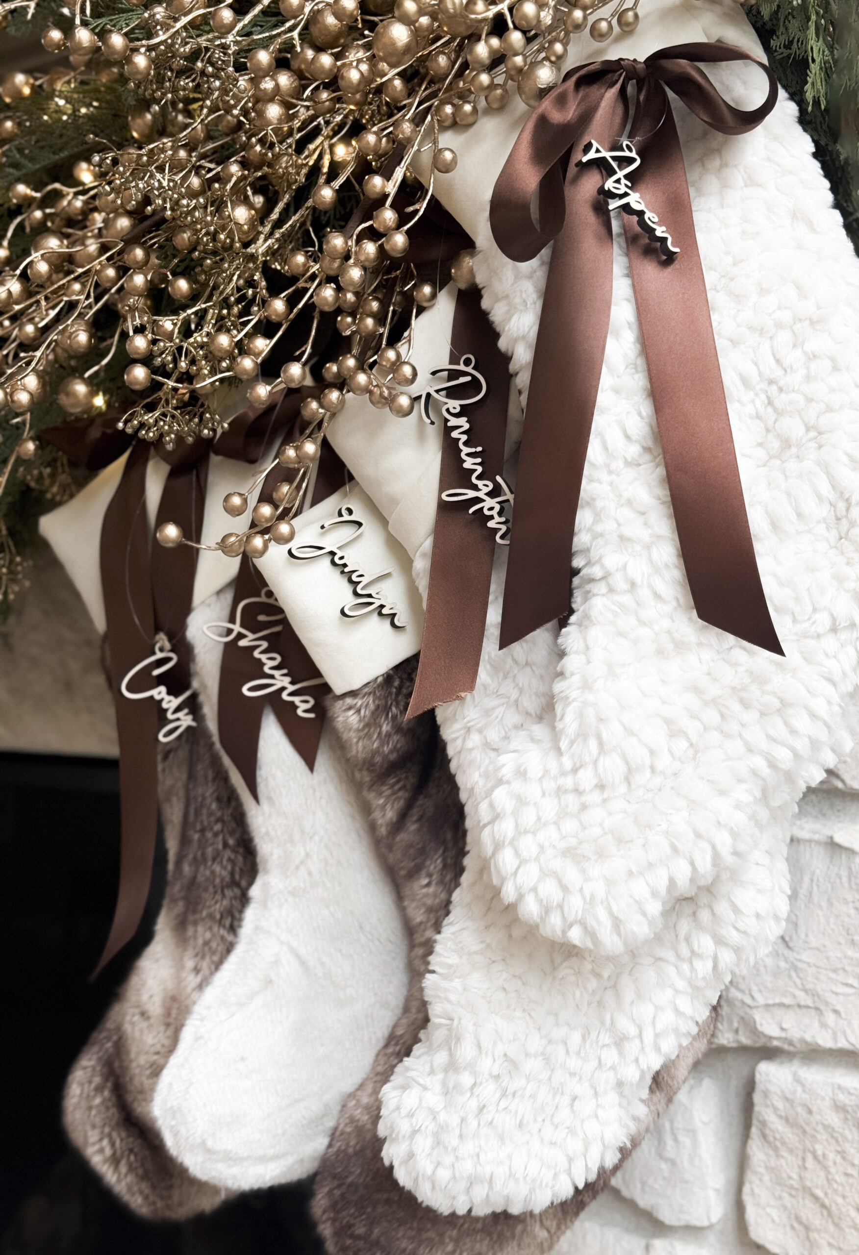 Mantel adorned with evergreen garland, hanging stockings, and warm holiday accents.