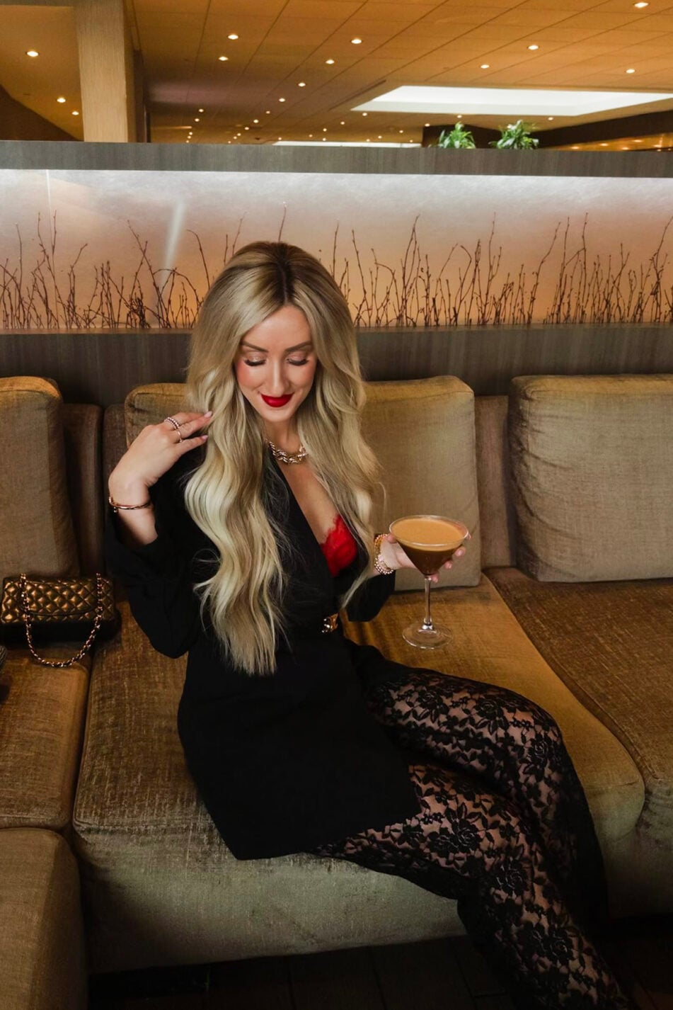 woman wearing black blazer, red top, black lace pants