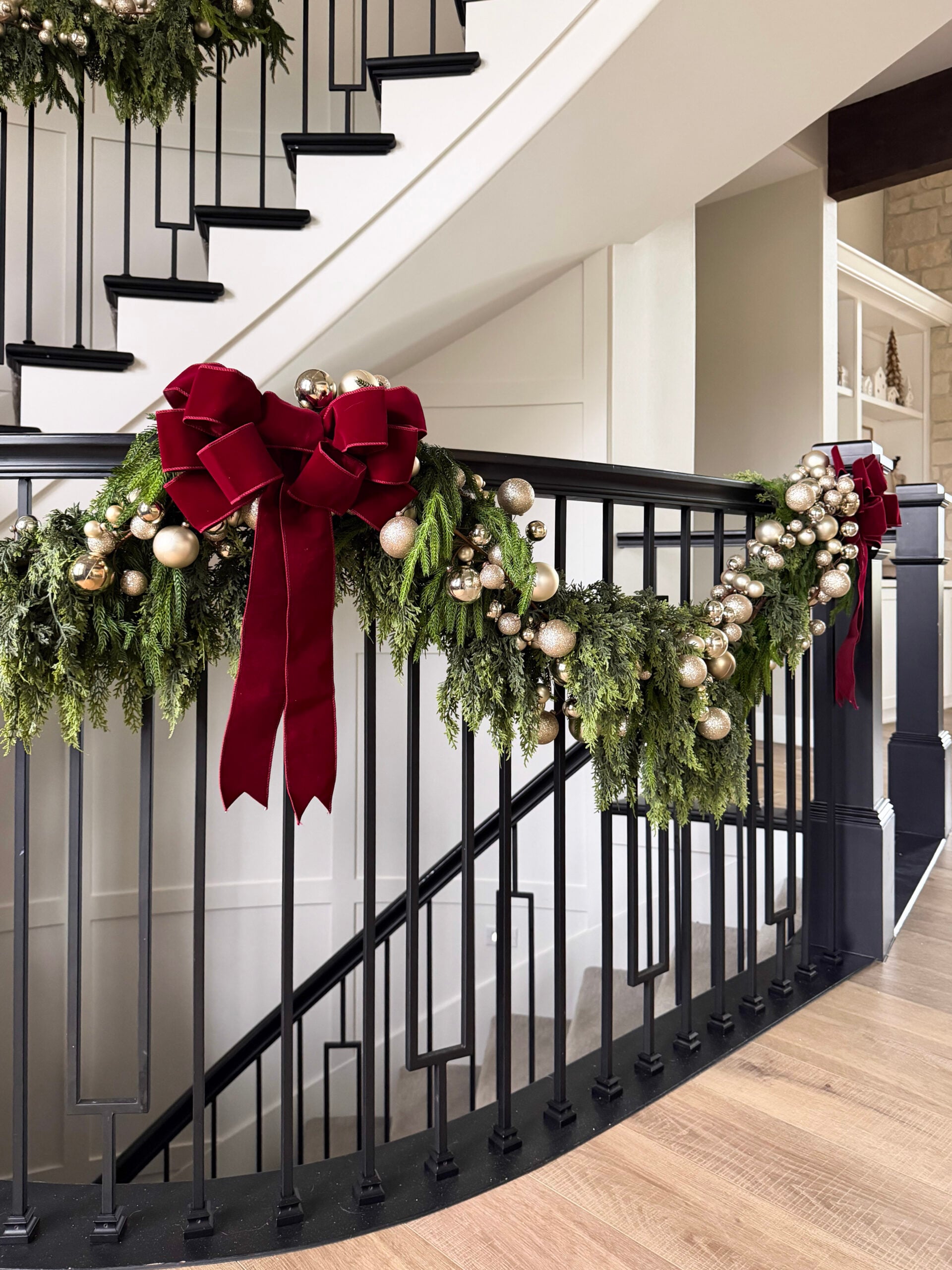 no regret holiday decor | staircase garland, red bow, ornament garland, twinkle lights, ribbon bow