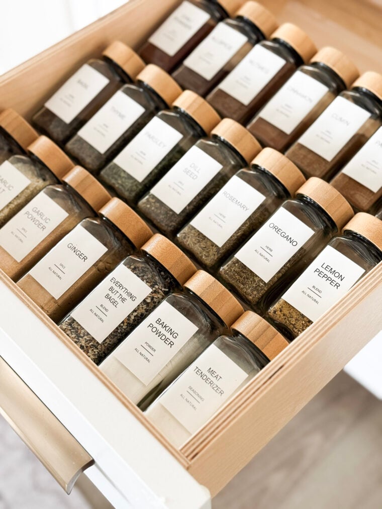 image of glass spice jars with minimalist labels in a kitchen drawer