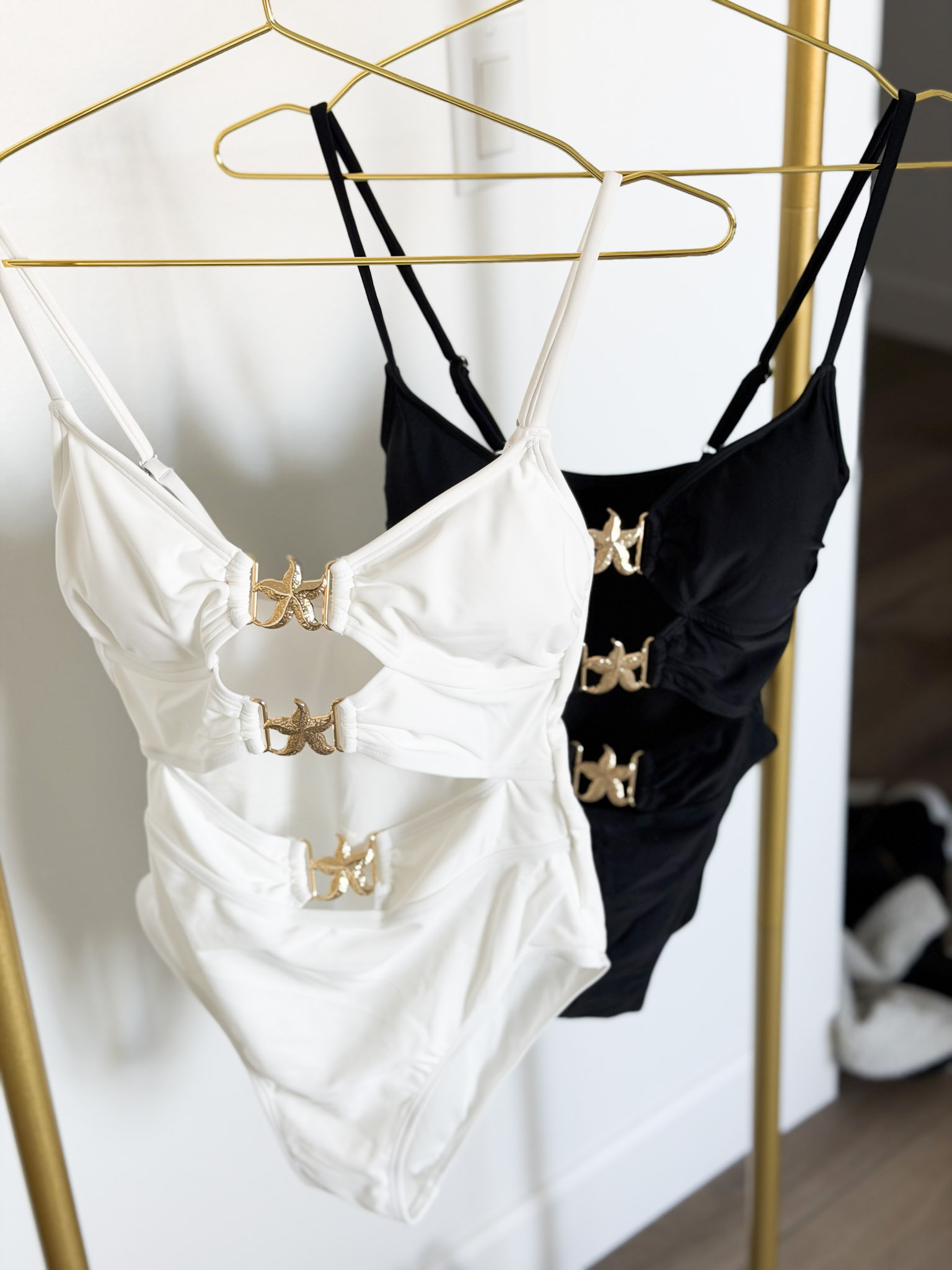 a white one-piece swimsuit, and a black one-piece swimsuit