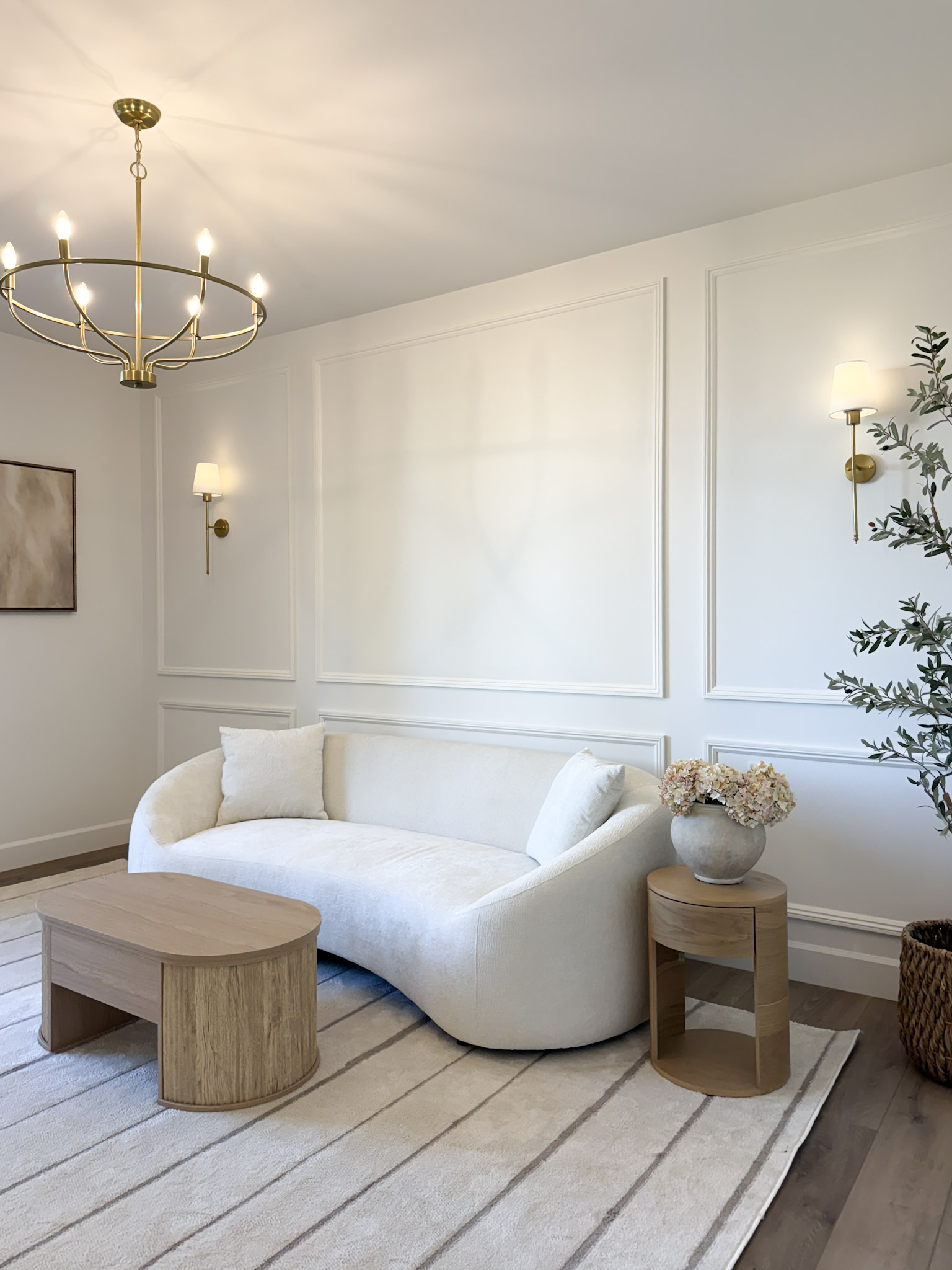 neutral room with coffee table, couch, and artwork on the wall