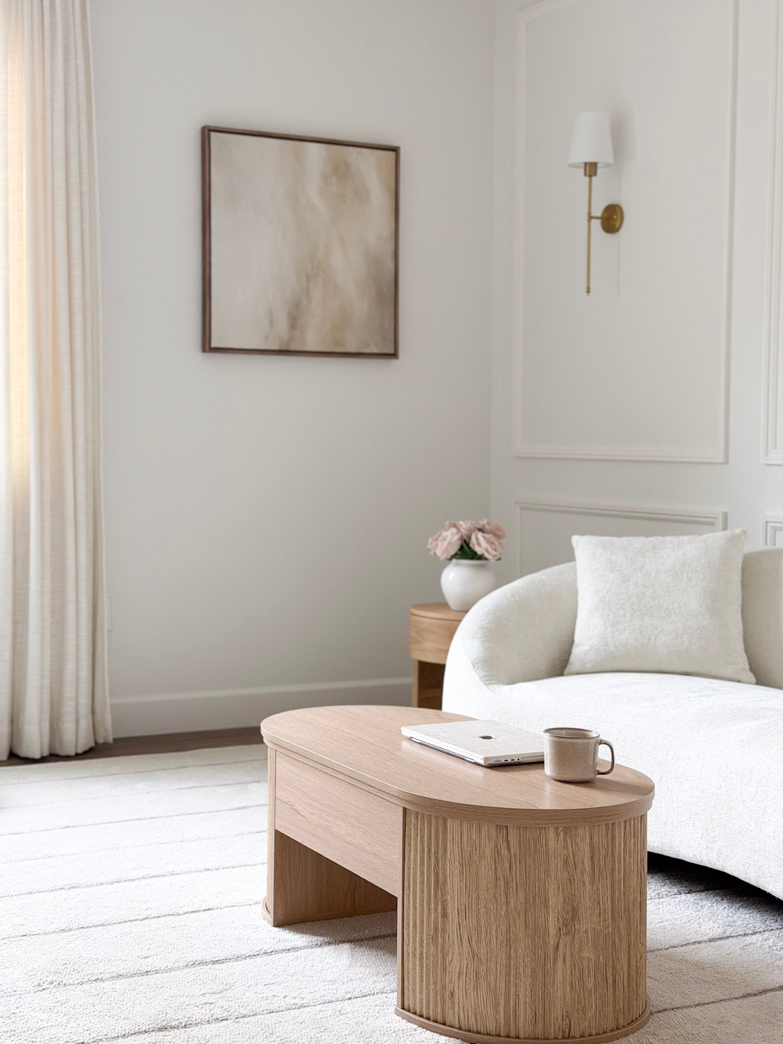 neutral room with coffee table, couch, and artwork on the wall