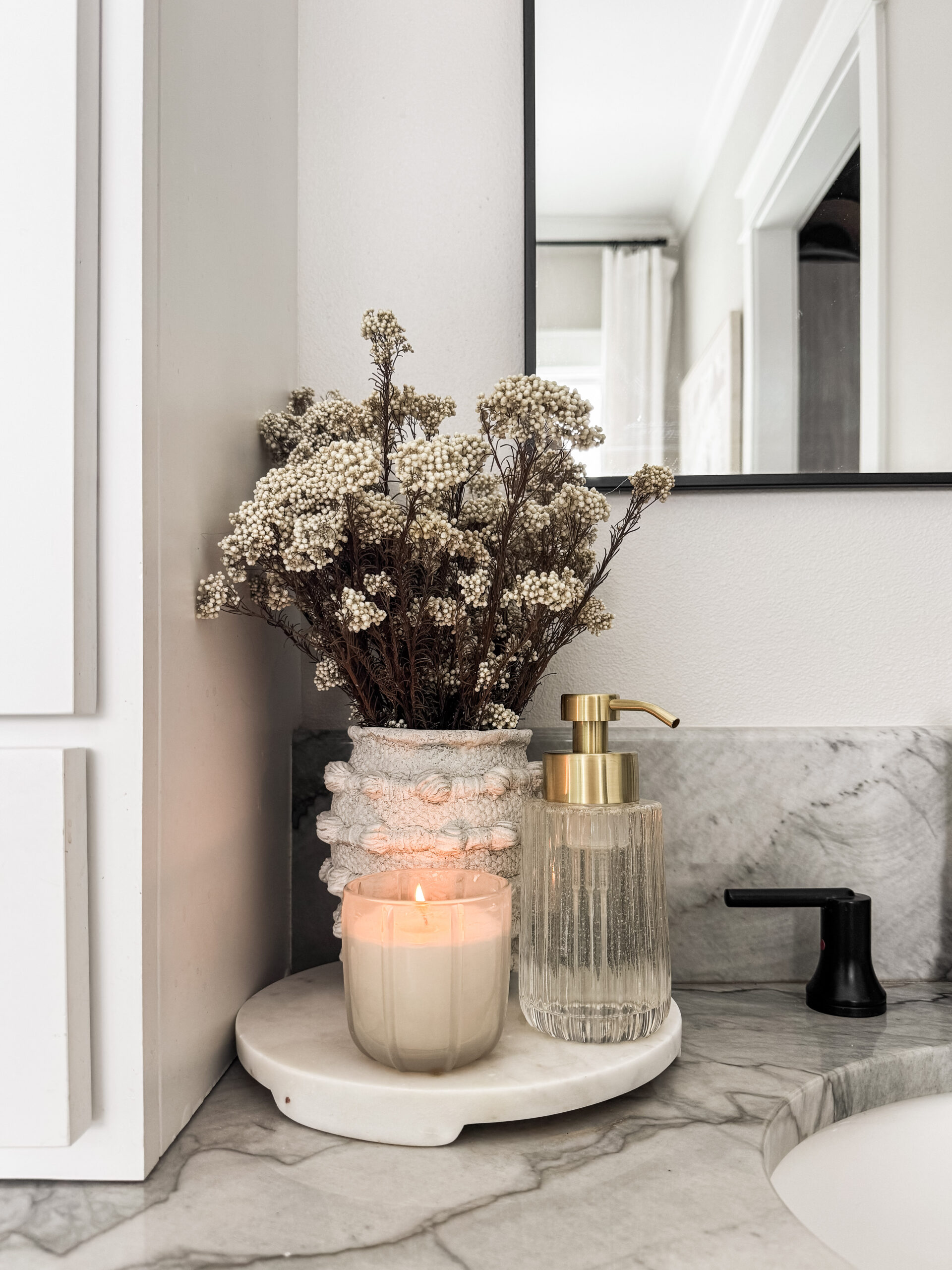 tray with candle, soap dispenser, and flowers