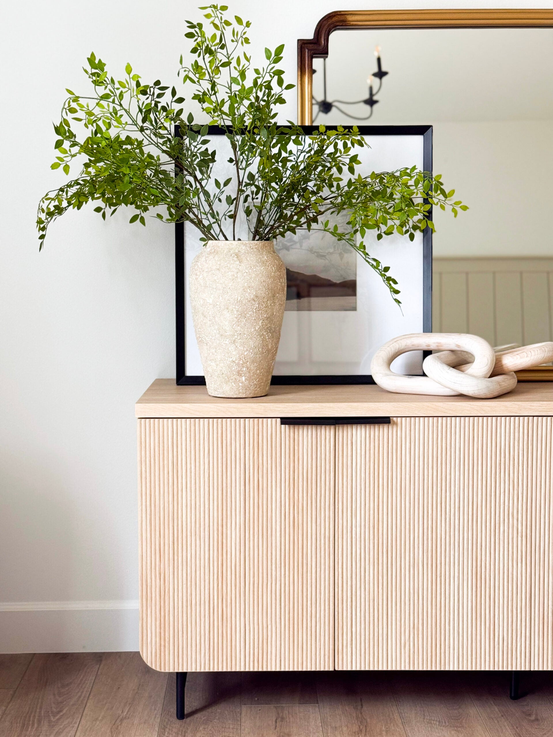 faux greenery in a vase on a dresser