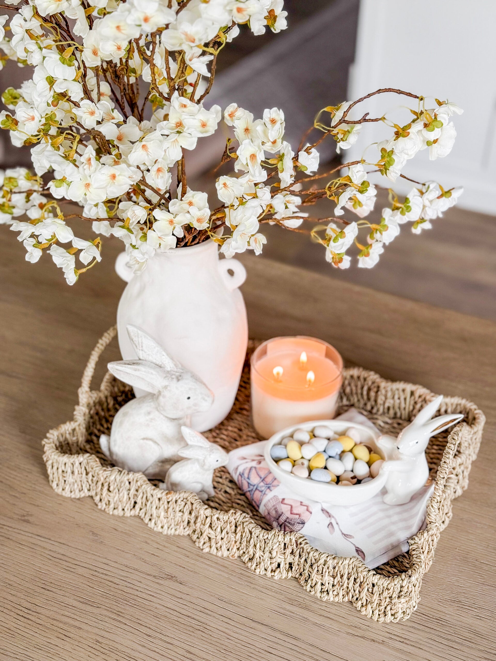 spring tray with faux cherry blossoms in a vase, bunny figurines, and candy