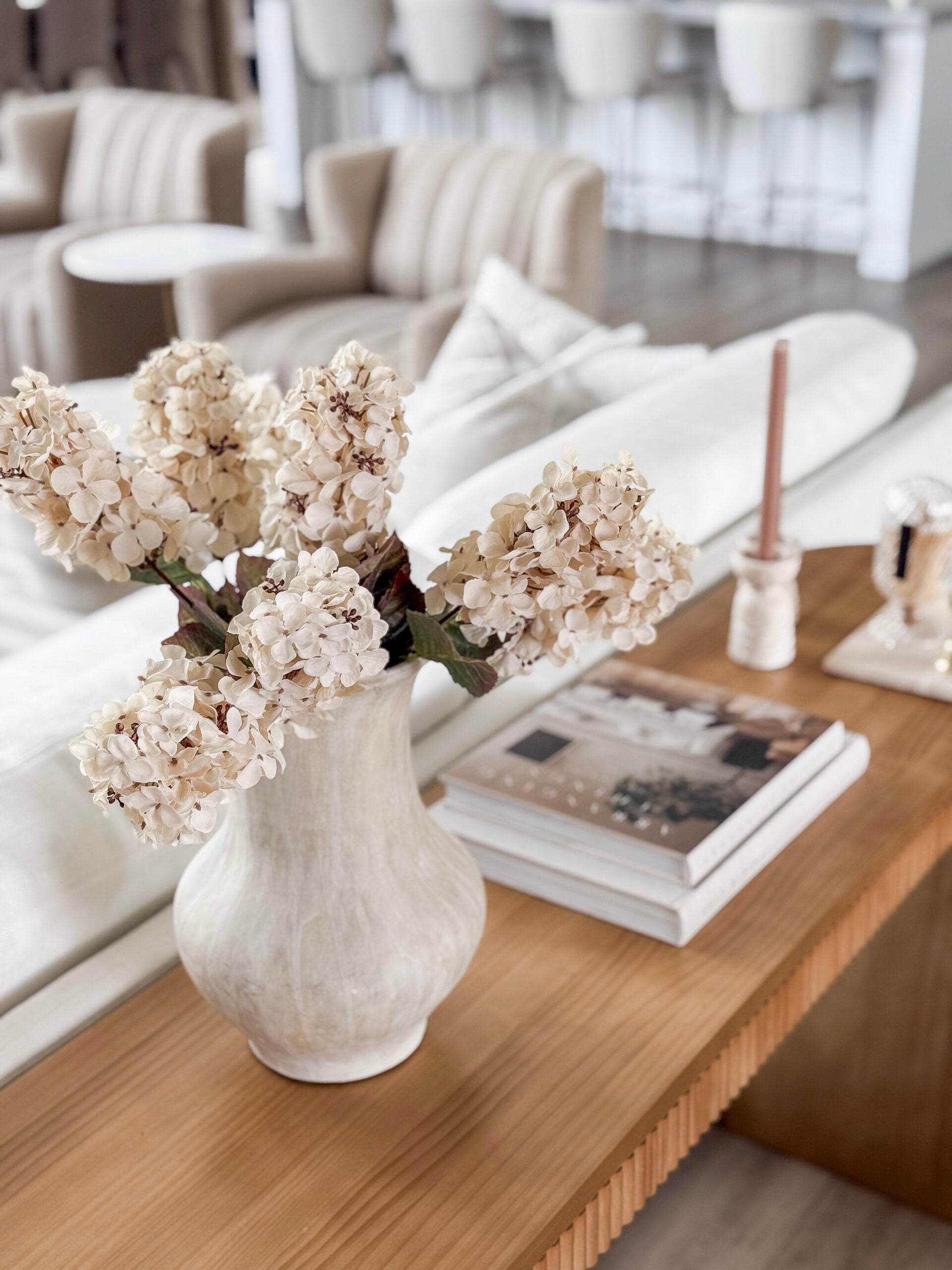 faux hydrangeas in a vase on an end table