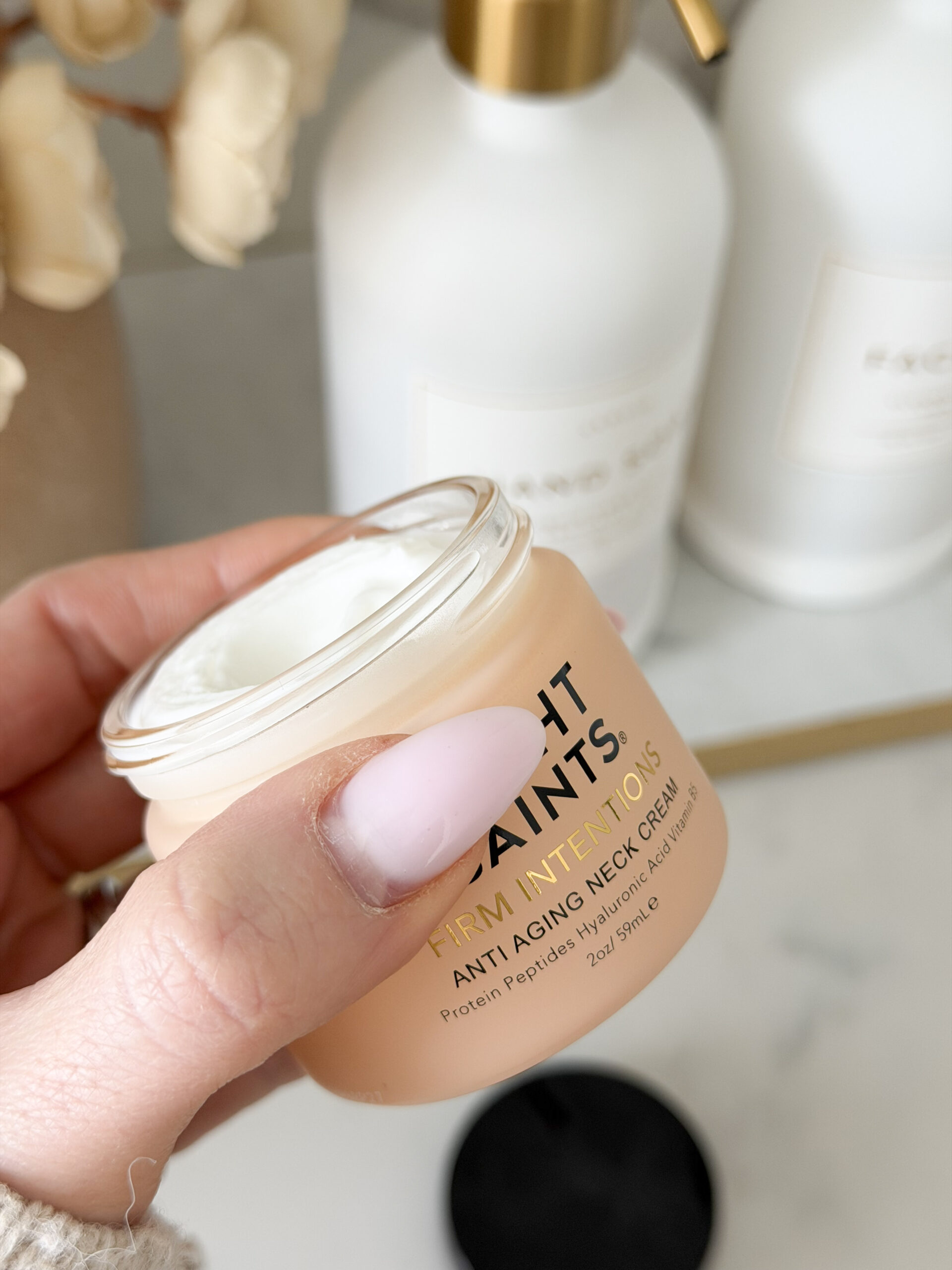 hand holding neck cream in a jar