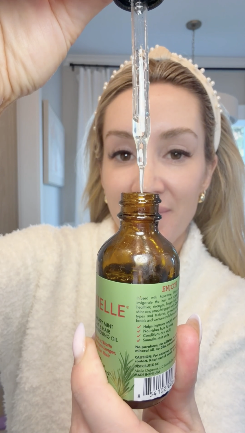 woman holding bottle of scalp oil