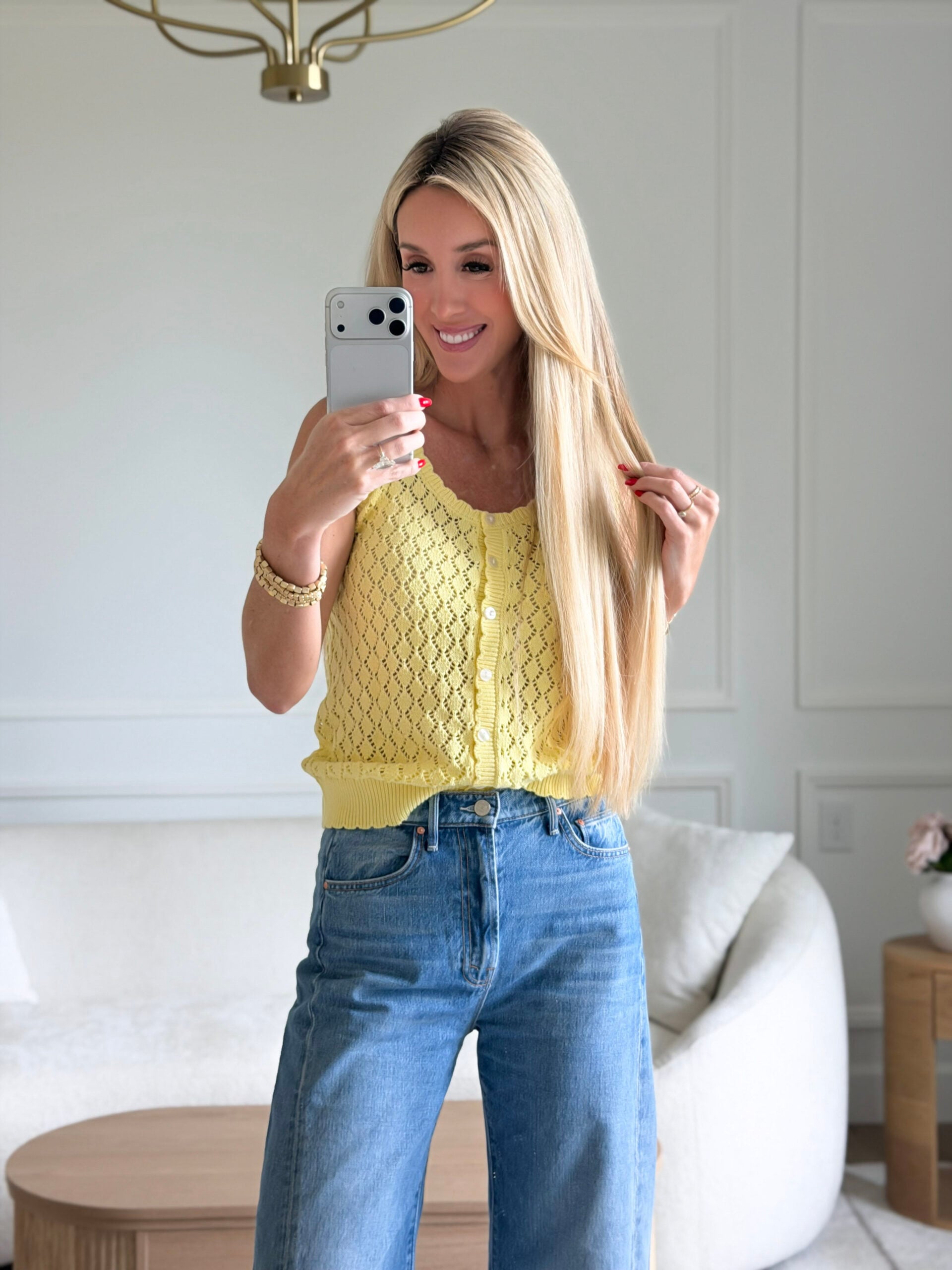 woman wearing yellow knit top and jeans