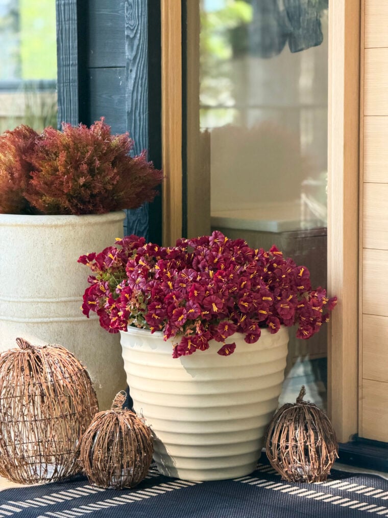 faux florals in a medium planter, rattan pumpkins, front porch styling